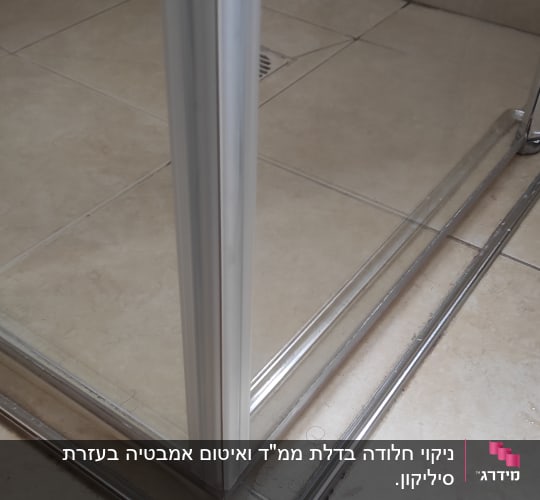 פינת מקלחון עם מסגרת מתכת על רצפת קרמיקה